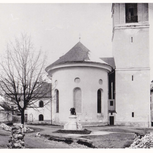 Ansicht des ehem. Vorplatzes vor der Erweiterung der Pfarrkirche. Im Bereich des heutigen Altares stand bis dahin das Denkmal zum Tiroler Freiheitskampf. Am linken Rand ist die alte Friedhofskapelle aus dem Jahr 1620 sichtbar. Sie wurde im Rahmen der Kirchenerweiterung 1912 aufgestockt und 1961 zur Taufkapelle umgestaltet.