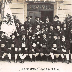 MGV Liederkranz Wörgl im Jahr 1928, Hintereingang der Neuen Post. Sitzend v.l.n.r.: Hans Gschöpf, Hans Hutterer sen. Konrad Schwingshackl, Hubert Ascher, Dr. Peter Zottl, Josef Gschöpf, Hans Hutterer jun. 2. R. v.l.n.r.: Hermann Rass, Franz Weikl, Anna Mager, Josef Kröll, Resi Pollak, Martin Mey, Lorenz Blattl, Egid Oberleitner, Alois Strasser, davor Johann Hackl. 3. R. v.l.n.r.: Gidi Walch, Alois Langmaier, Franz Höpfl, N. Langebner